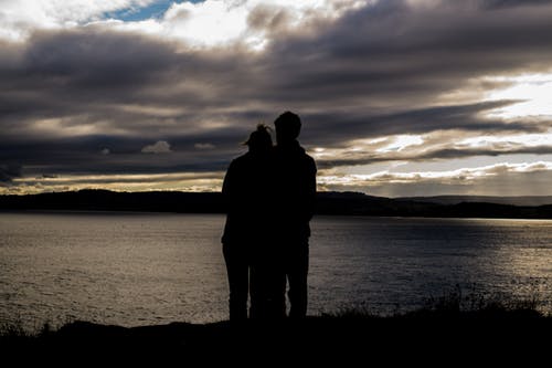 Two individuals suffering from addiction looking out over the water