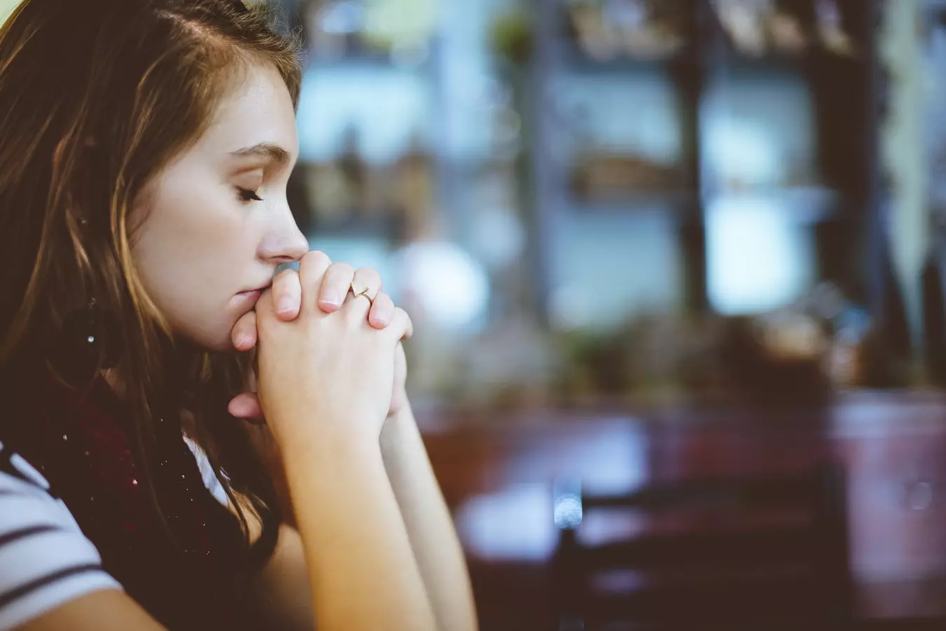 A woman praying and hoping for a healthy recovery from addiction