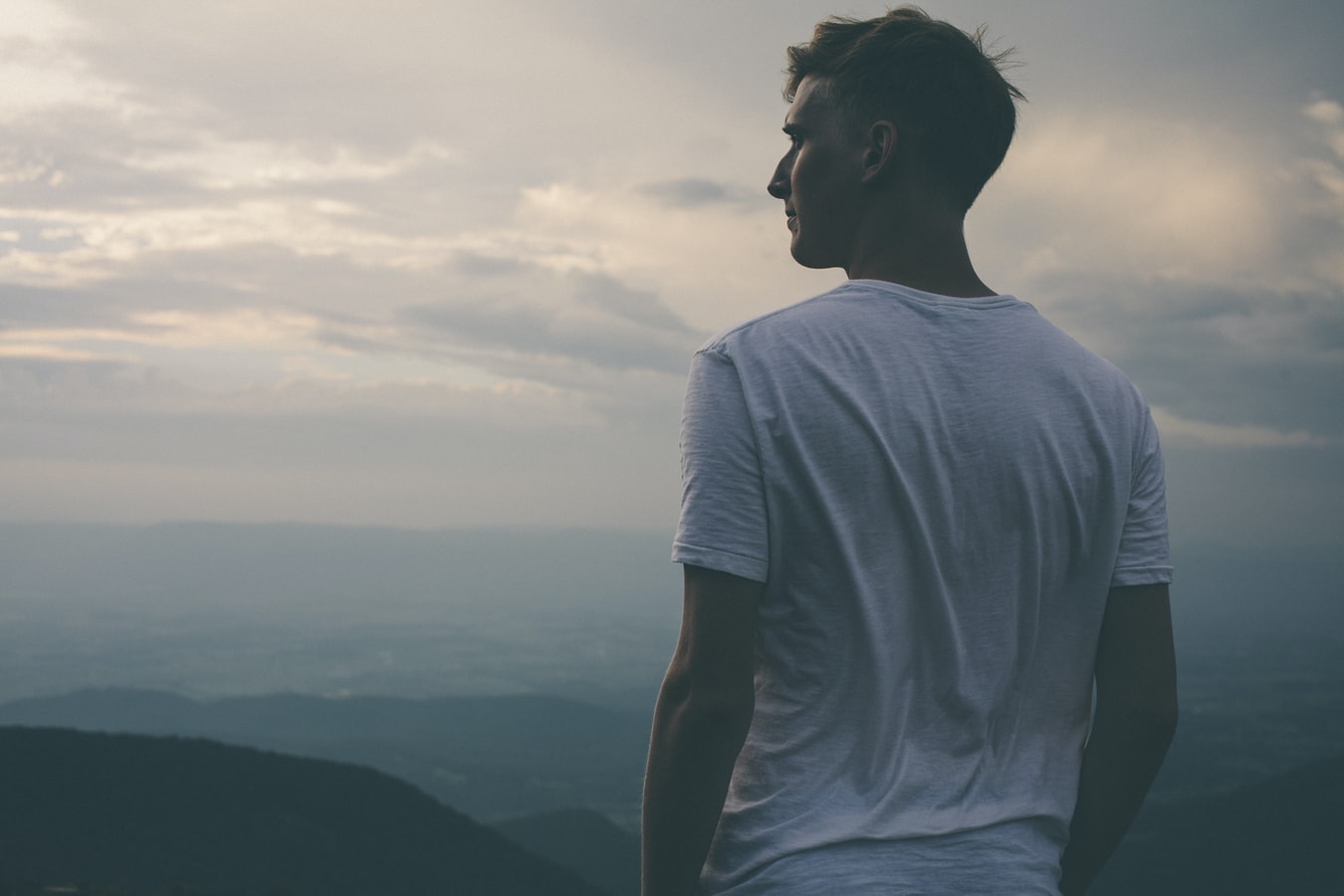 A man standing on a mountain and wondering if he is enabling an addict