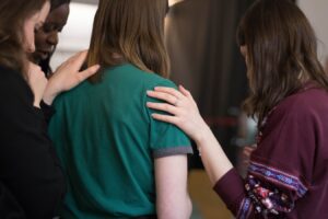 Women surrounding their friend who is asking for help for an addiction