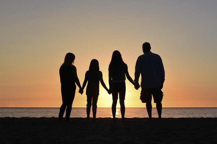A family watching the sunset on the beach together