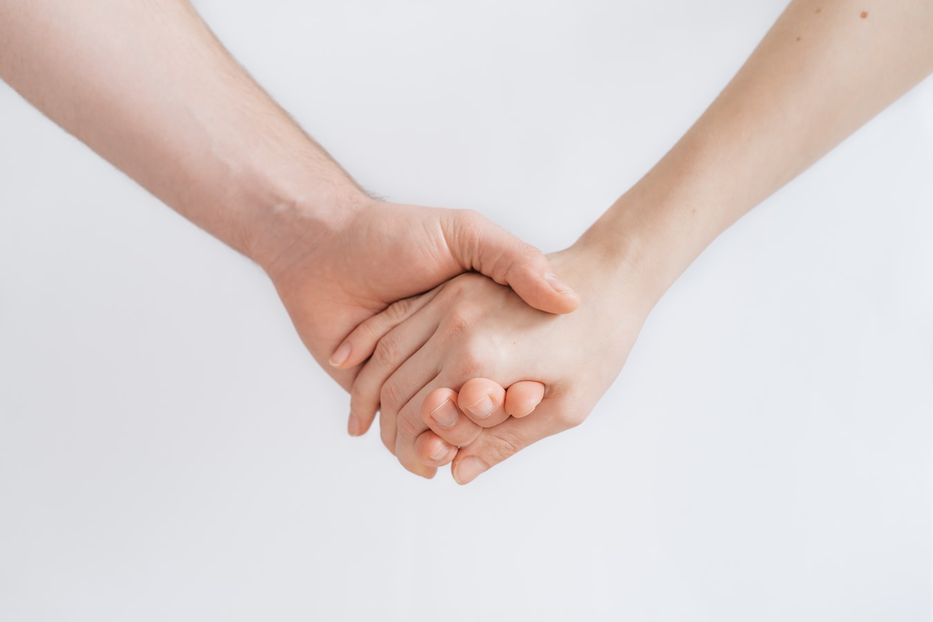 An individual holding another persons hand as a sign of help