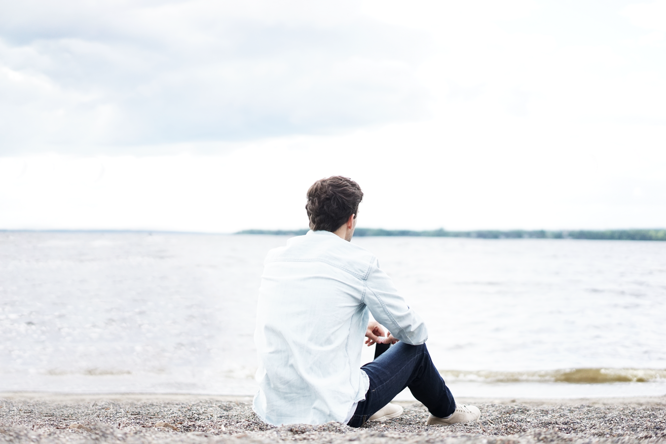 A man sitting near the water thinking about gabapentin