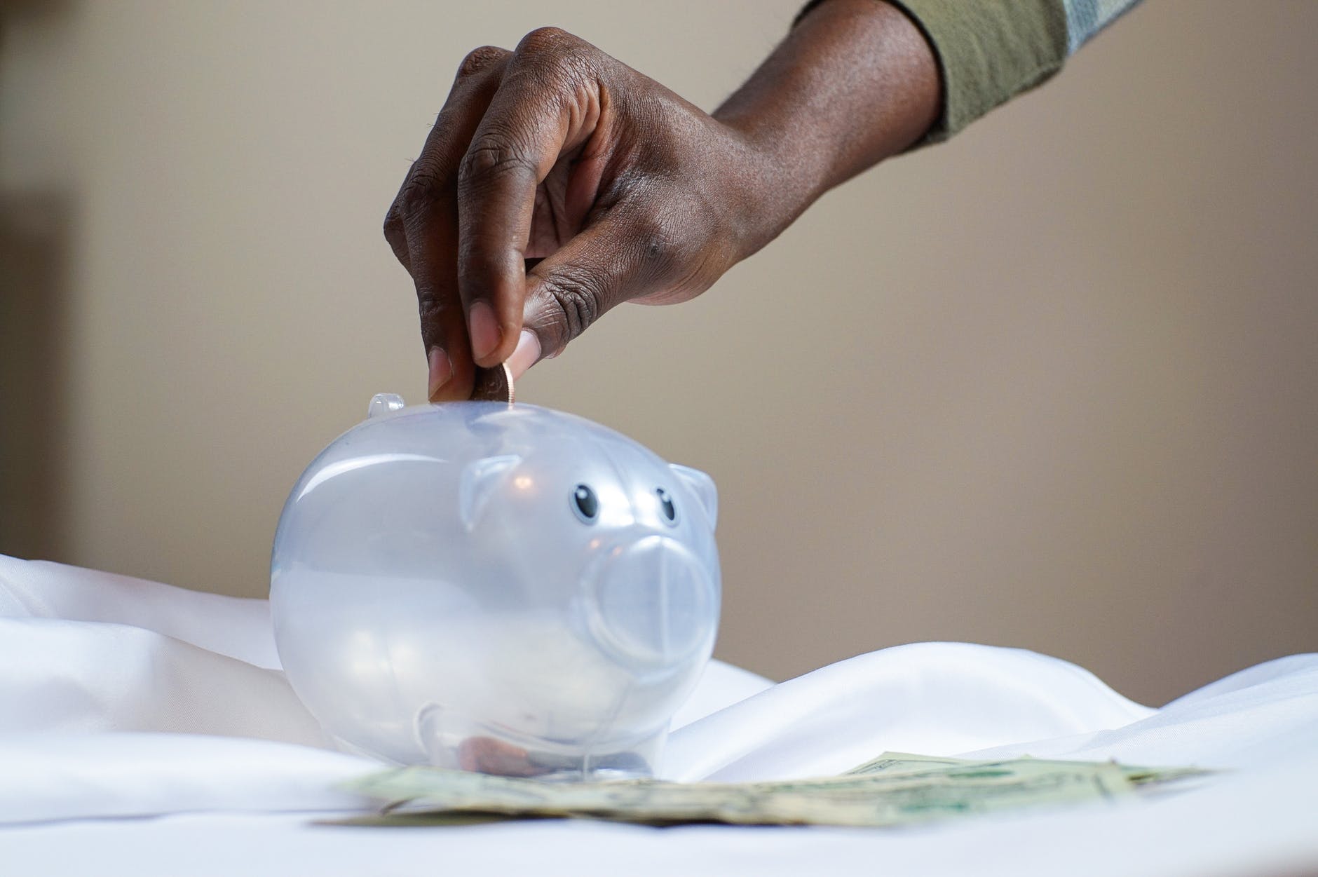 A man putting money in a piggy bank so he can attend an IOP program