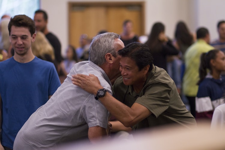 Individuals greeting eachother at an Alcoholics Anonymous meeting