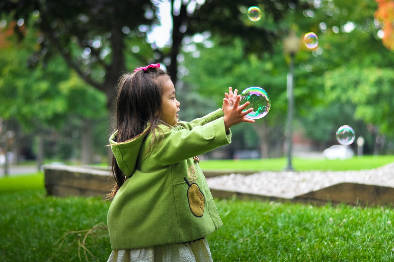 A young girl outside playing with bubbles. Parents who engage in alcohol use in Oklahoma can have lasting effects on their childrens lives