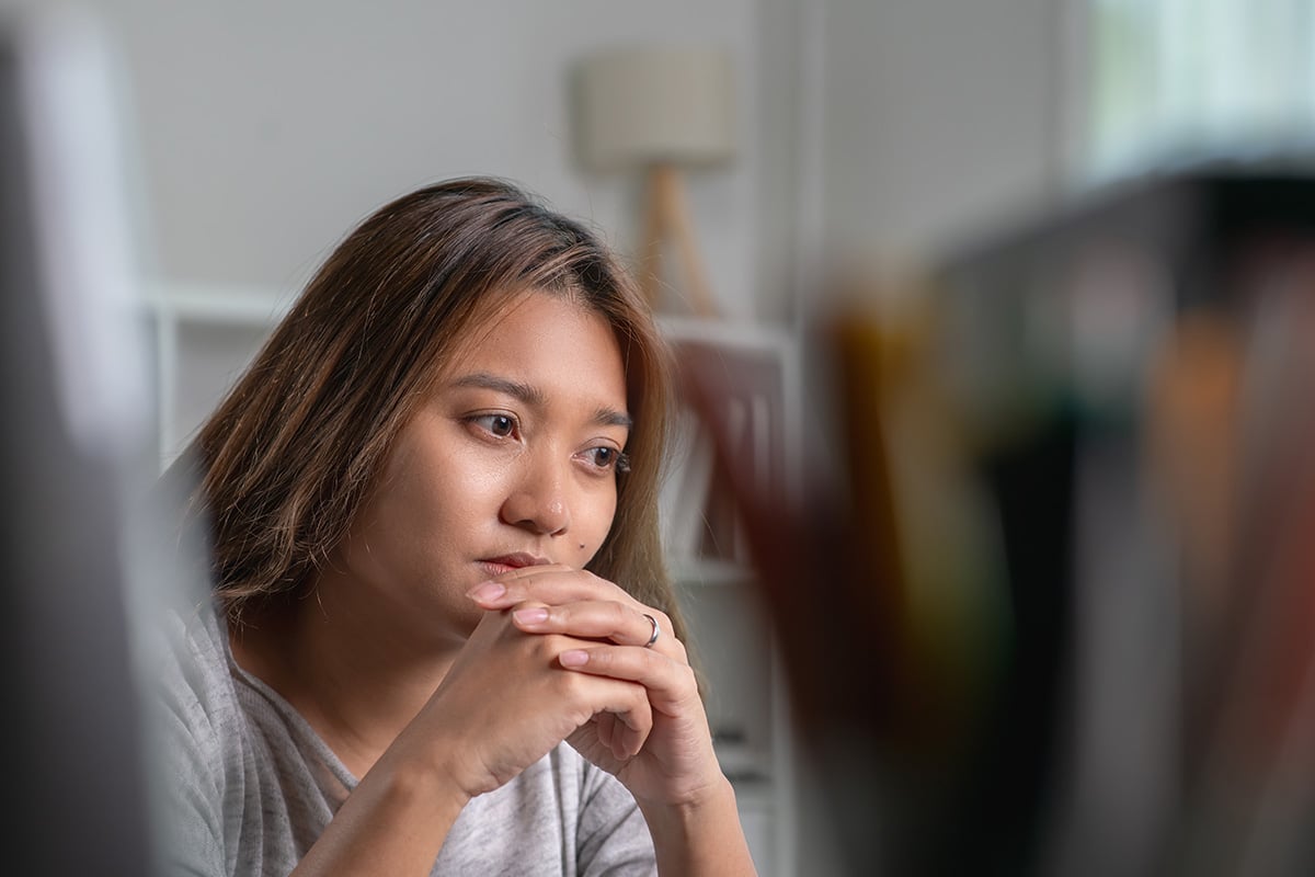 person with hands folded in deep thought about the sociocultural model of addiction
