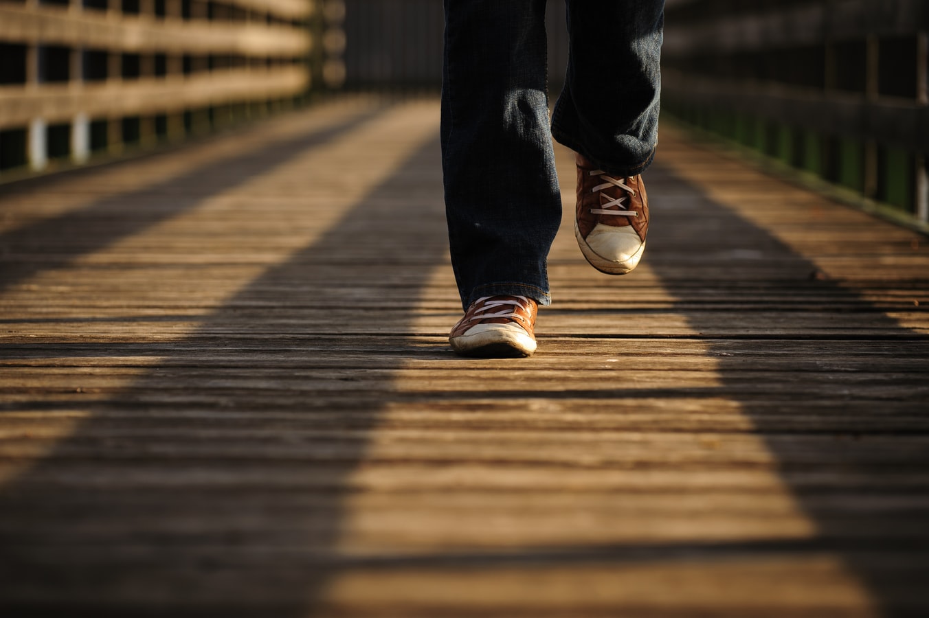 An individual walking on a bridge.