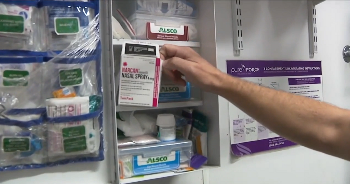 A Sexy Pizza employee in Denver reaches for Narcan in the first-aid cabinet