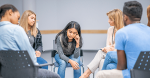 A group therapy session uses the Seeking Safety model for addiction treatment concerning substance use disorder, trauma and specifically PTSD.