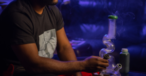 Man smoking weed via bong at an X-Train party  where there was allegedly drug and alcohol abuse, possibly even heroin use.