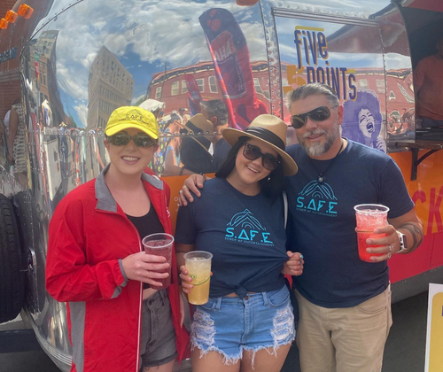 two women and a man hold mocktails during a sober af entertainment tailgate at a music festival at five points music festival with mocktails