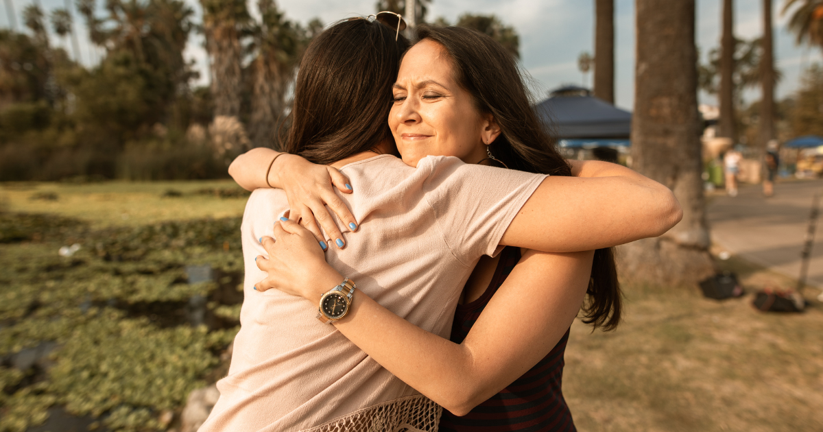two women hug each other and support one another at a halfway house to overcome addiction