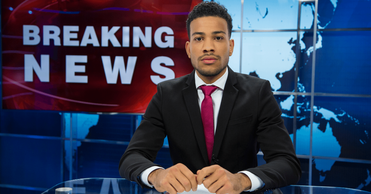 Black news anchor sits at desk for Breaking News on air, pertaining to drugs.