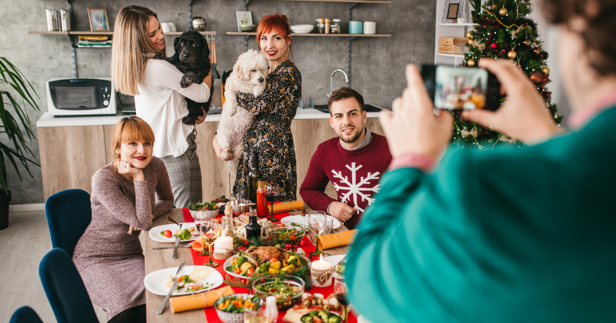 a man in addiction recovery takes a picture of friends during a christmas party