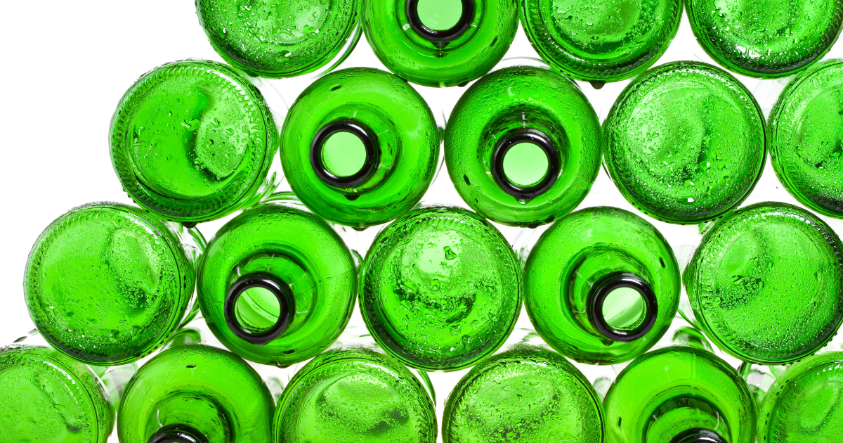 Empty green beer bottles artfully stacked.