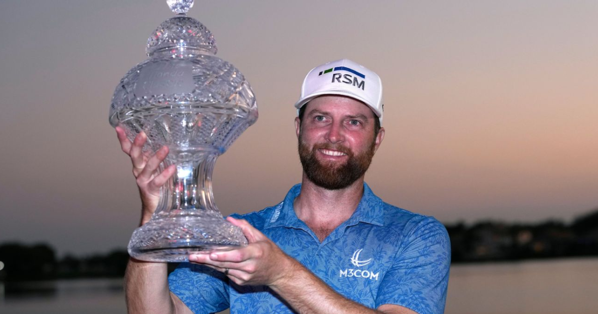 PGA golfer Chris Kirk holds up a glass trophy after winning the Honda Classic.