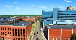 An aerial view of the city of Kalamazoo with brick buildings in the foreground and a glass building in the background. The city has been pursuing claims in an opioid lawsuit against Meijer supermarket chain.