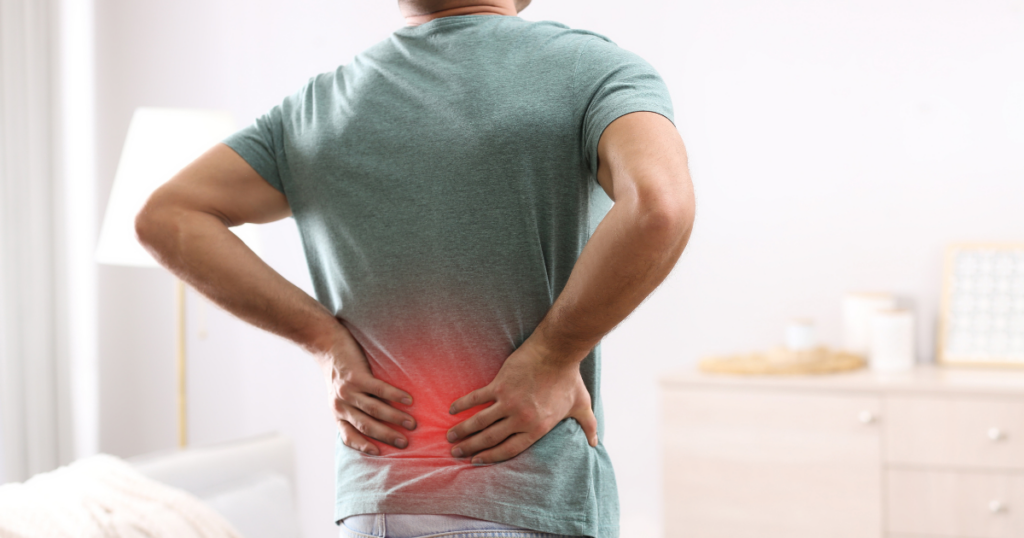 A man holds his back in pain. He suffers from fibromyalgia and uses opioids to relieve his pain