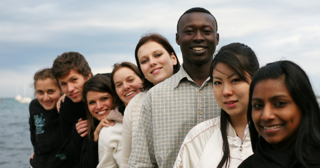 a group of different races of teens and young adults stand together. The NSDUH breaks down its 2021 report into different ethnicities to describe teen and young adult substance use.