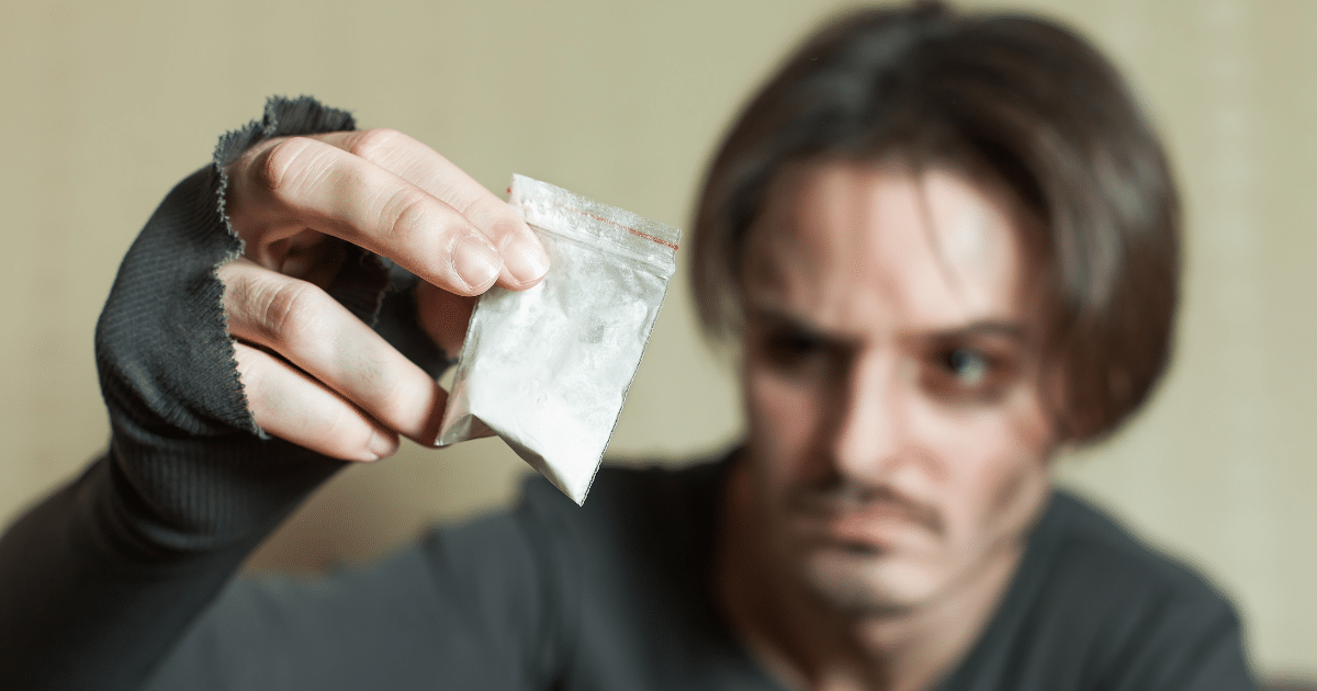 a man holds a bag of cocaine powder and risks overdoing