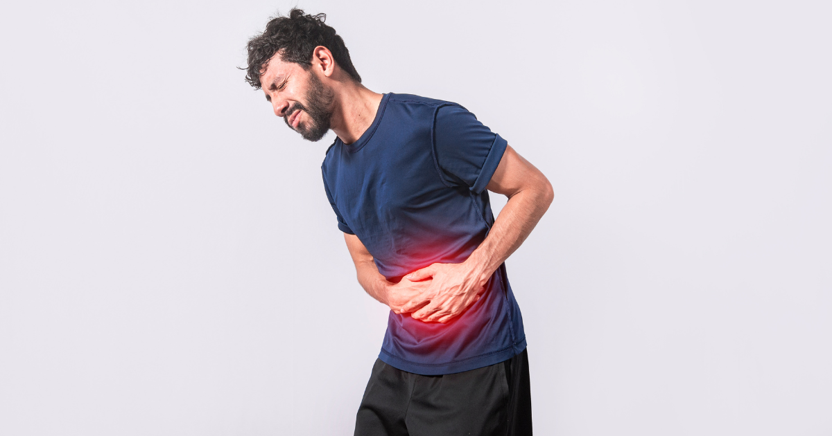 a man holds his stomach experiencing constipation after using cocaine