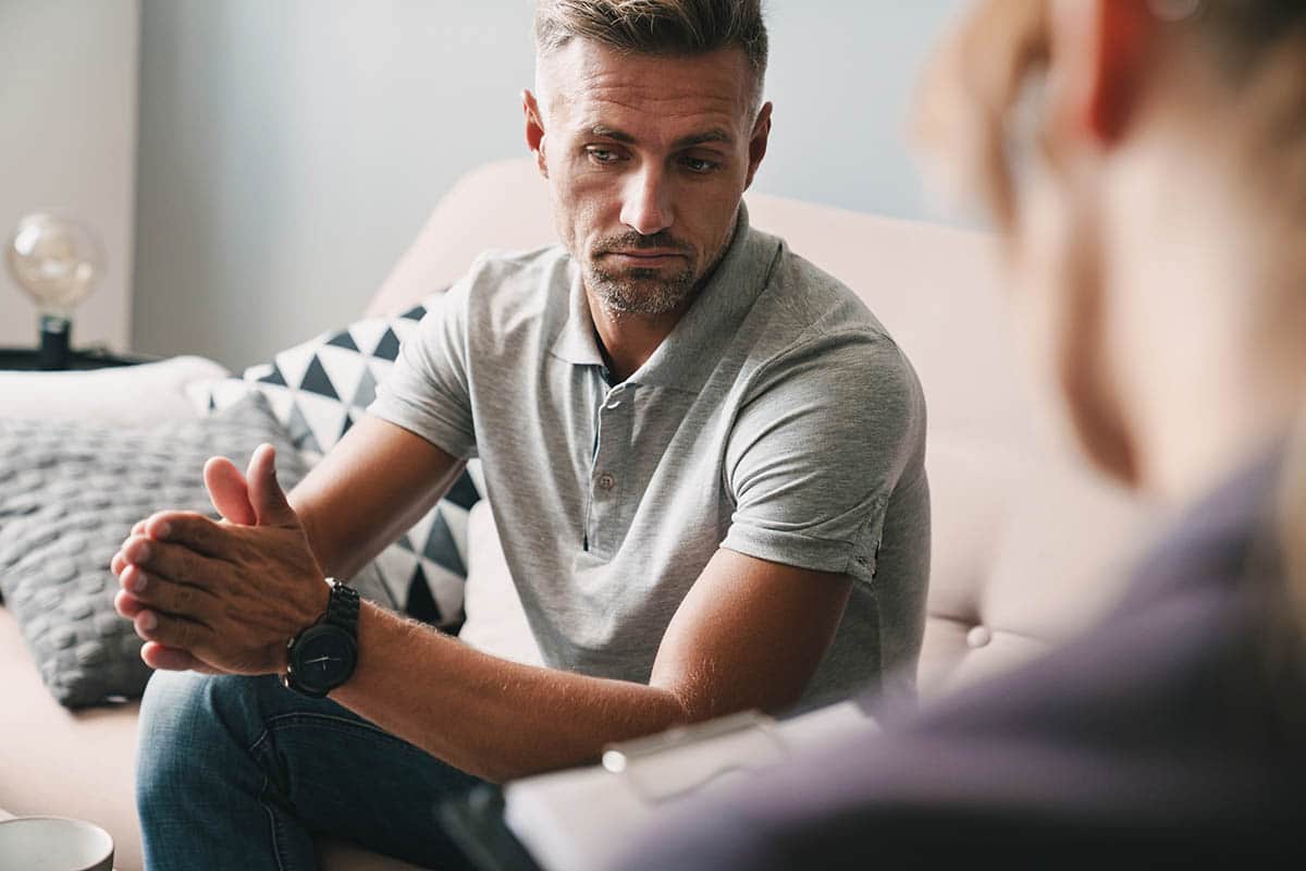 therapist talking with engaged young man about what to expect in a men's rehab center in Colorado Springs